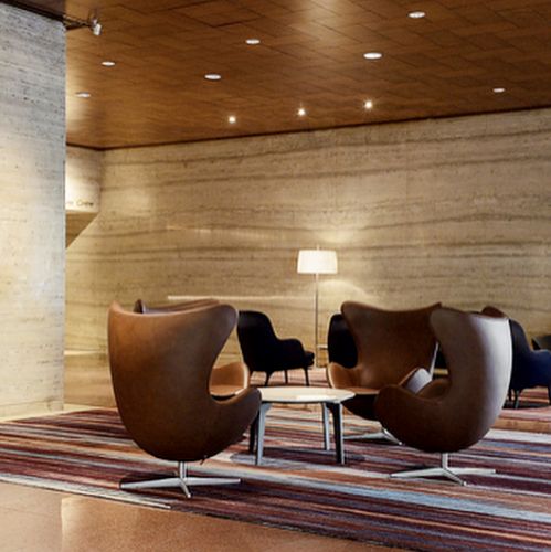 Seating area with Arne Jacobsen's Egg™ chairs from Fritz Hansen crafted with brown Sørensen Leather.
