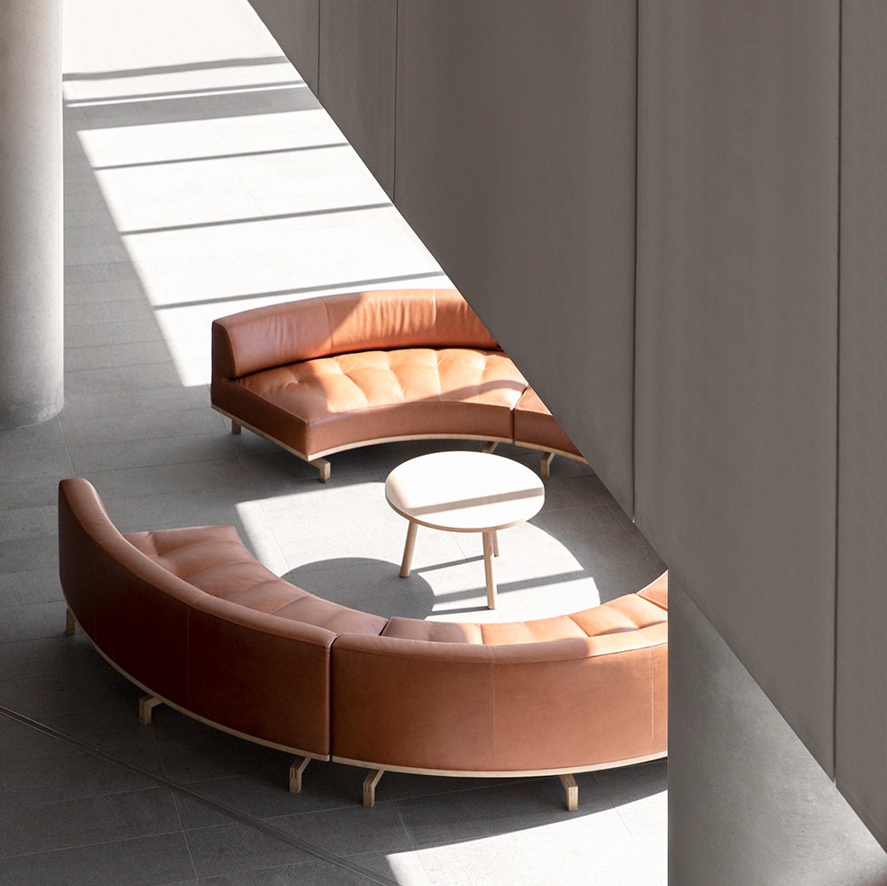 Round, brown leather sofa inside industrial building