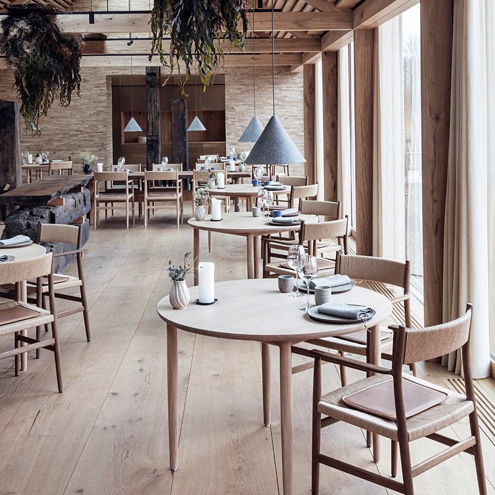 Restaurant interior with wooden tables and chairs featuring cushions crafted with Sørensen Leather DUNES