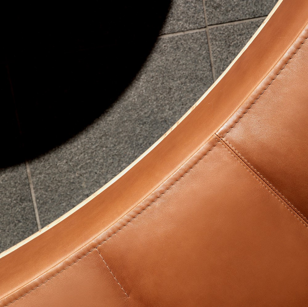 Sewing details of round, brown leather sofa