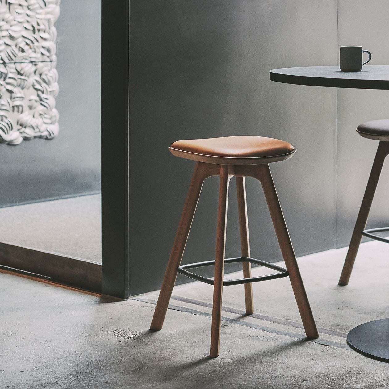 Wooden bar stool crafted with a brown leather seat